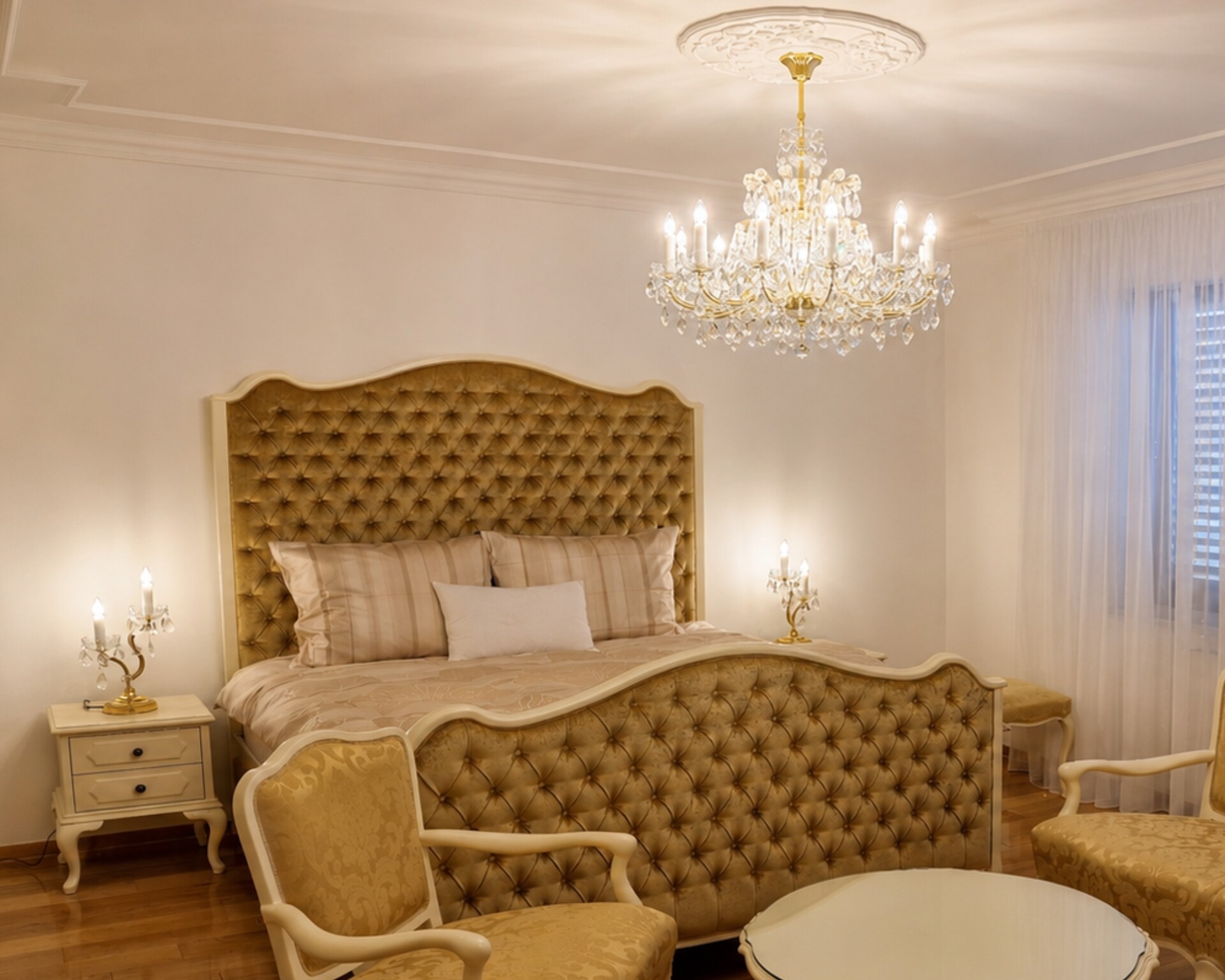Hauptschlafzimmer im neobarocken Stil mit einem großen Maria-Theresia-Kristallkronleuchter über dem Bett