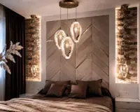 Gruppe hängender Glasleuchten über dem Bett in einem Schlafzimmer mit Steinwand