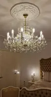 Marie-Theresien-Kristallleuchter in Goldausführung in einem luxuriösen Schlafzimmer mit gepolsterten Möbeln