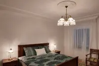 Messingtischlampen mit Glaskuppel und Kristallbehängen auf Nachttischen im Schlafzimmer
